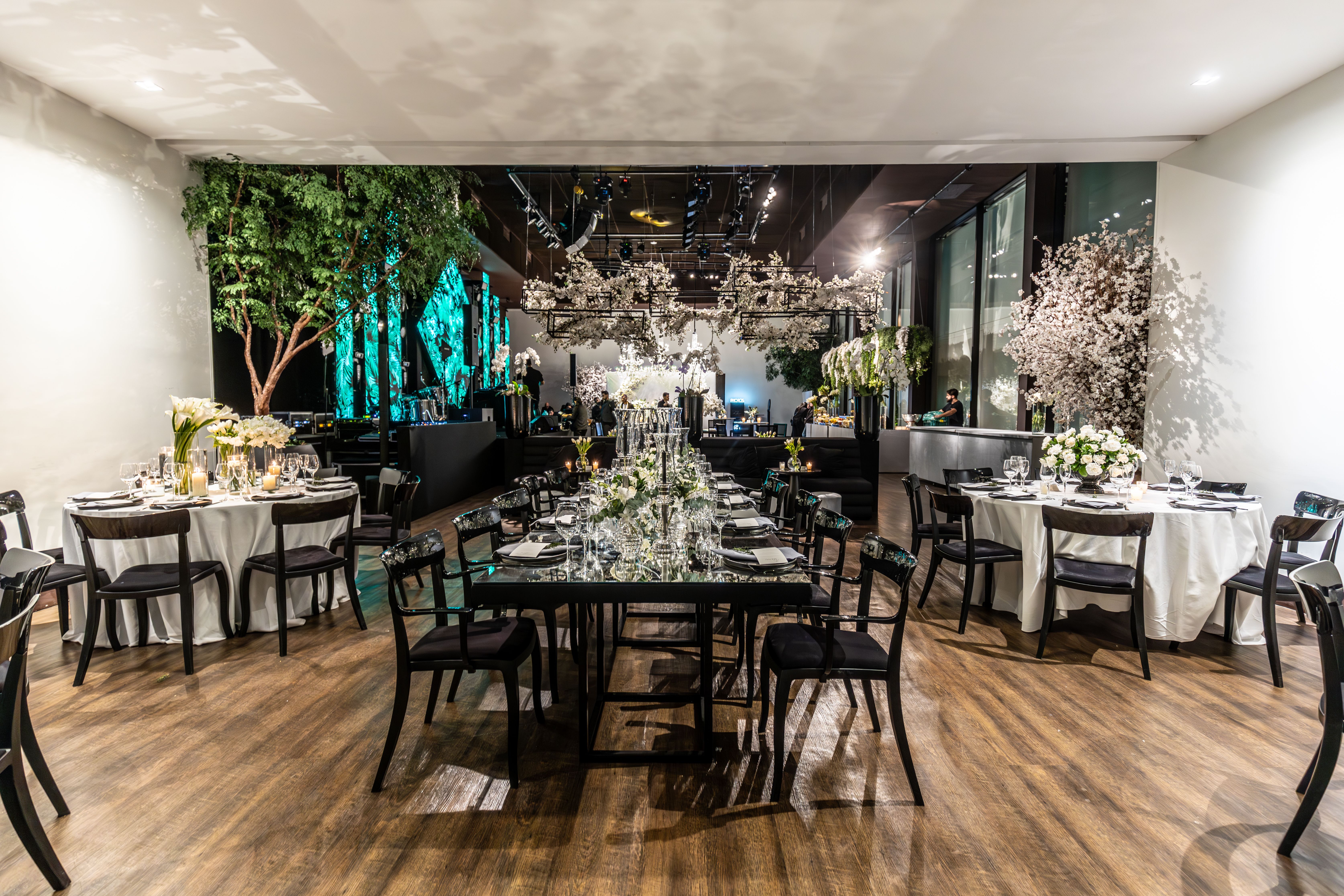 Elegant eingedeckter Eventsaal für eine Firmenfeier mit Blumenschmuck
