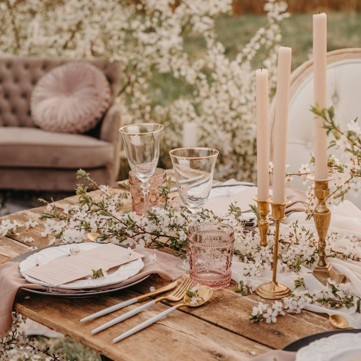 Tablescape mit Blüten und goldenen Kerzenständern